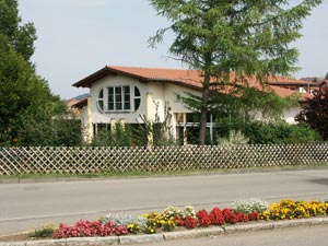 Kindergarten Kleinengstingen mit Bäumen, Gartenzaun und Blumenbeet